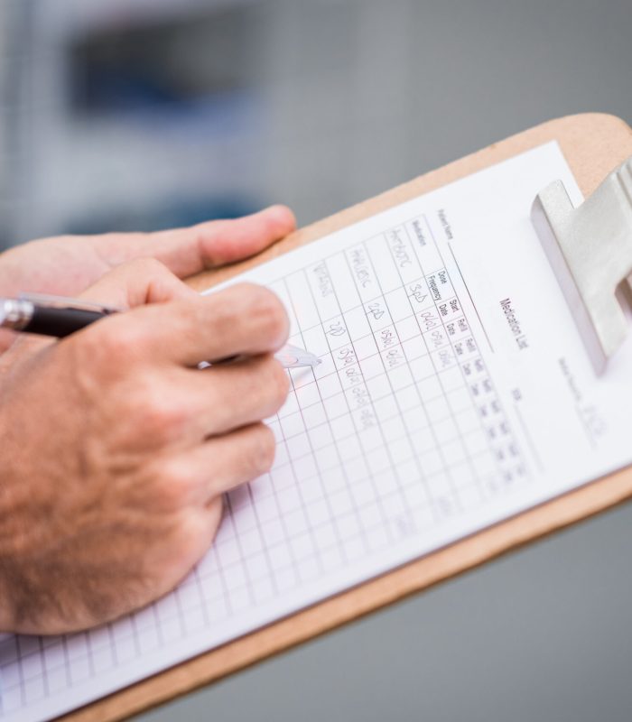 Close up of doctor hand filling medication list for a patient. Detail of hand of senior nurse complete the form of medicine. Doctor writing list of patient medicine in a hospital.